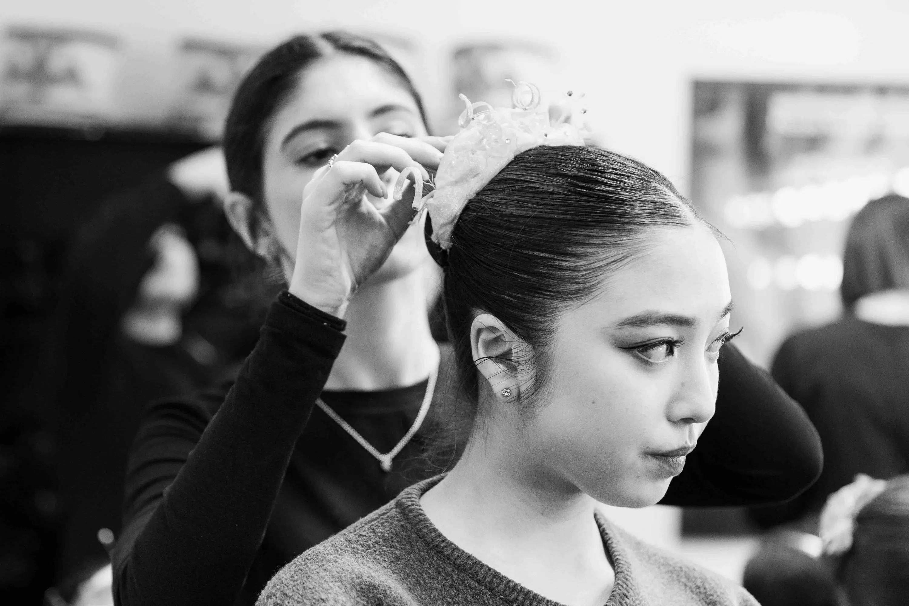 Una ragazza sistema il fermaglio tra i capelli di una ballerina