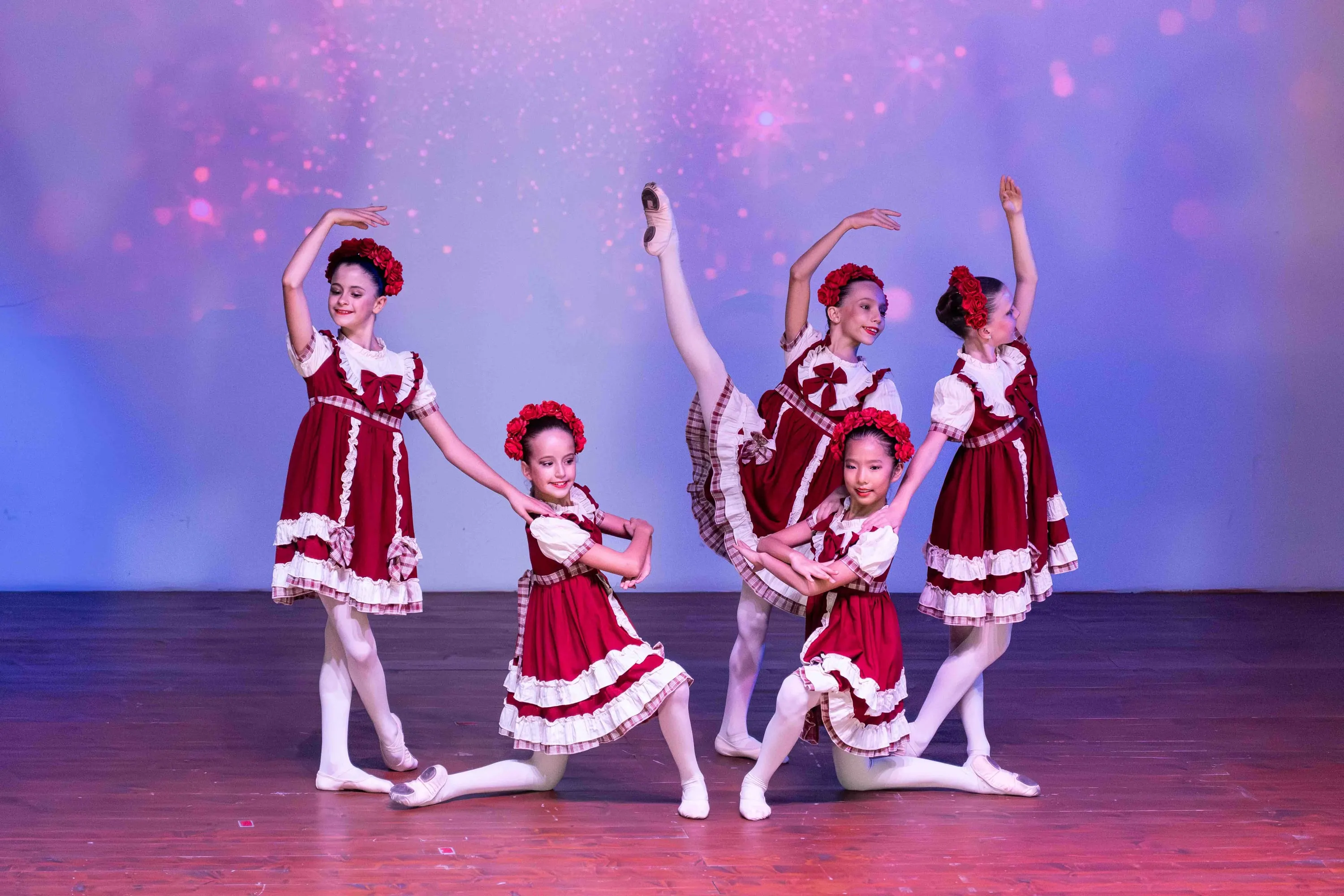 Un gruppo di bambine in costumi rossi in posa sul palco