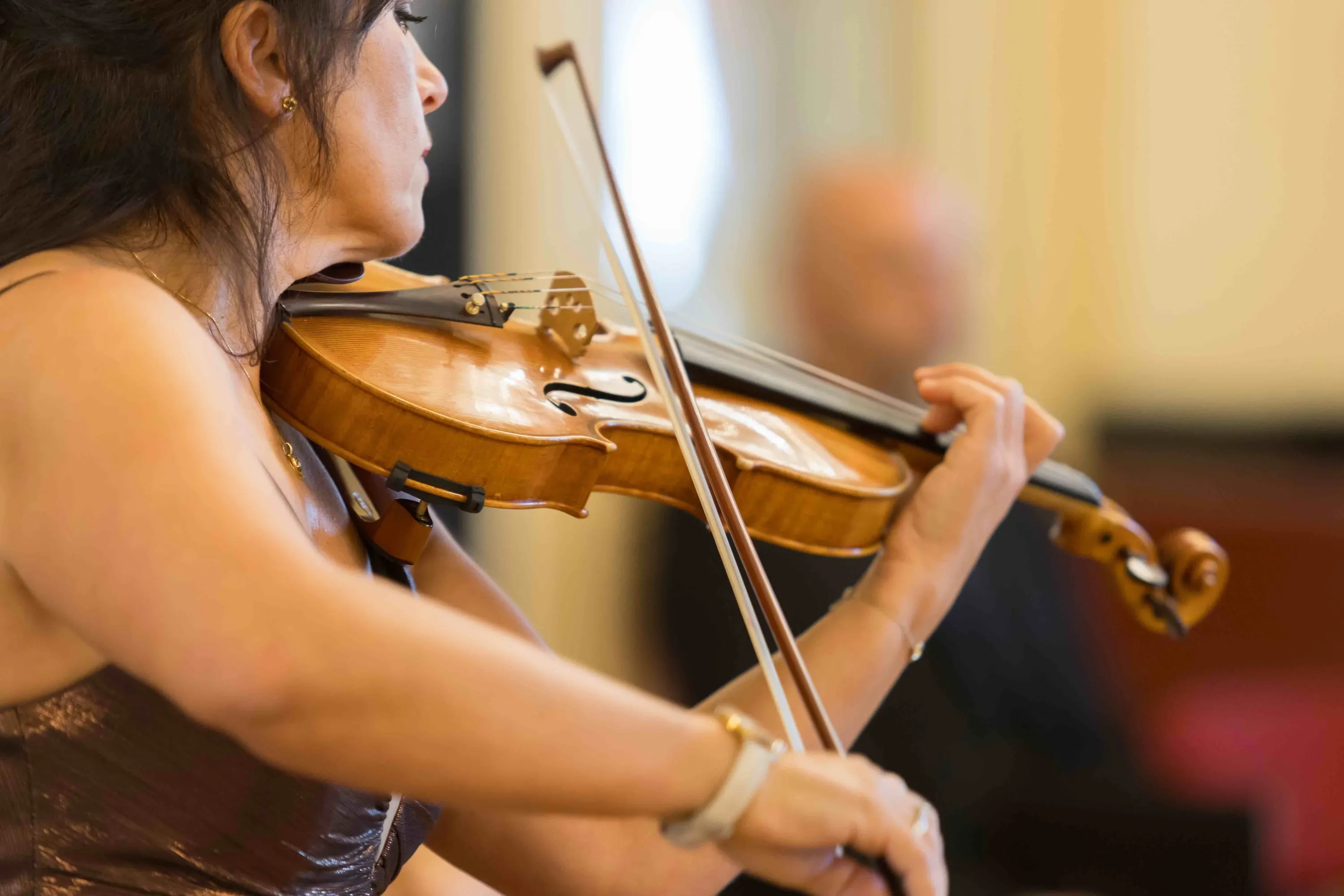 Una violinista suona, ripresa di profilo in primo piano
