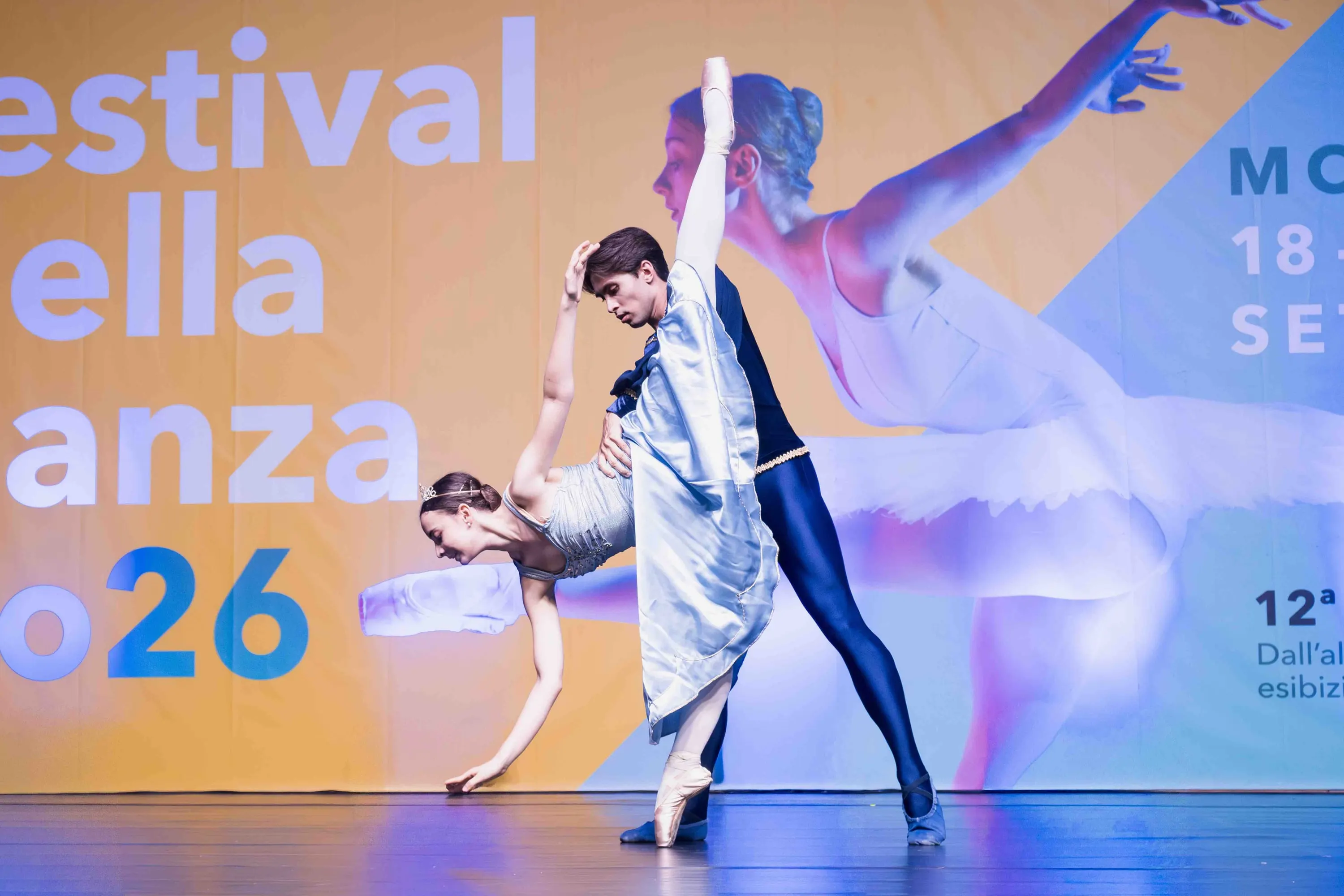 Un ballerino accompagna la compagna in un ampio cambré