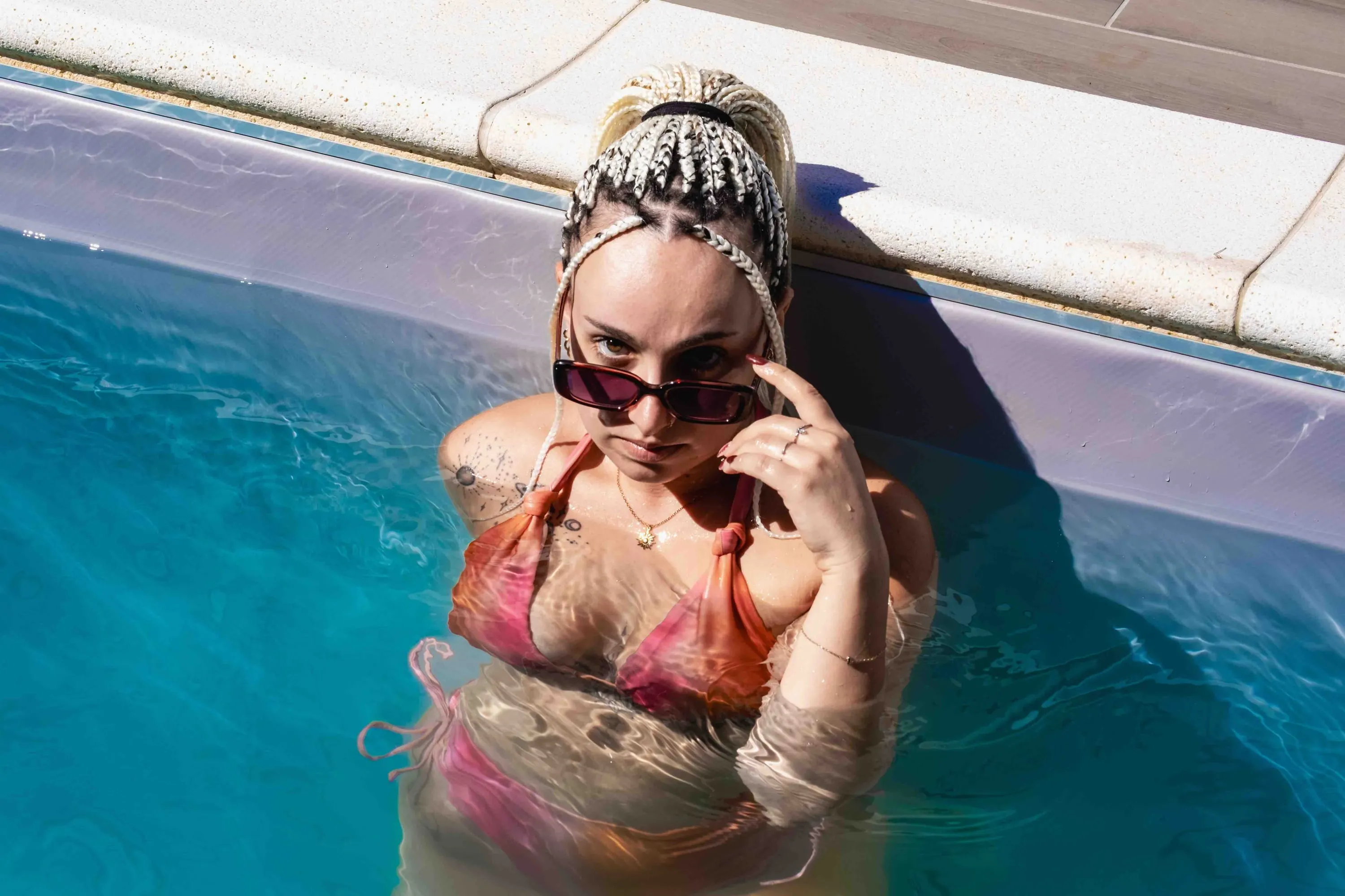 La ragazza in acqua abbassa gli occhiali da sole