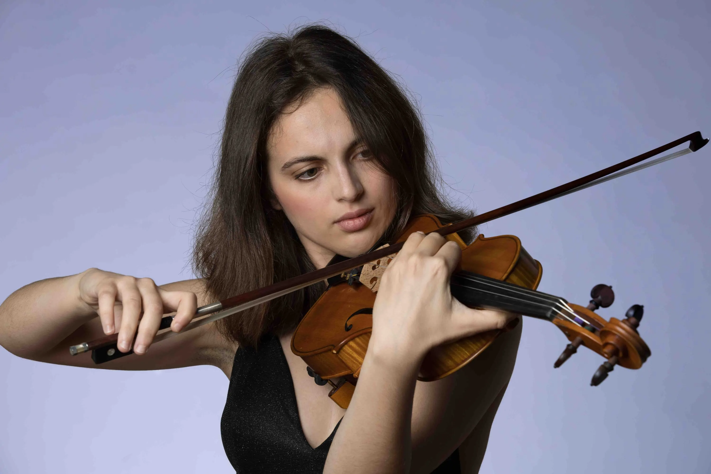 Ritratto di una giovane violinista su fondo lilla