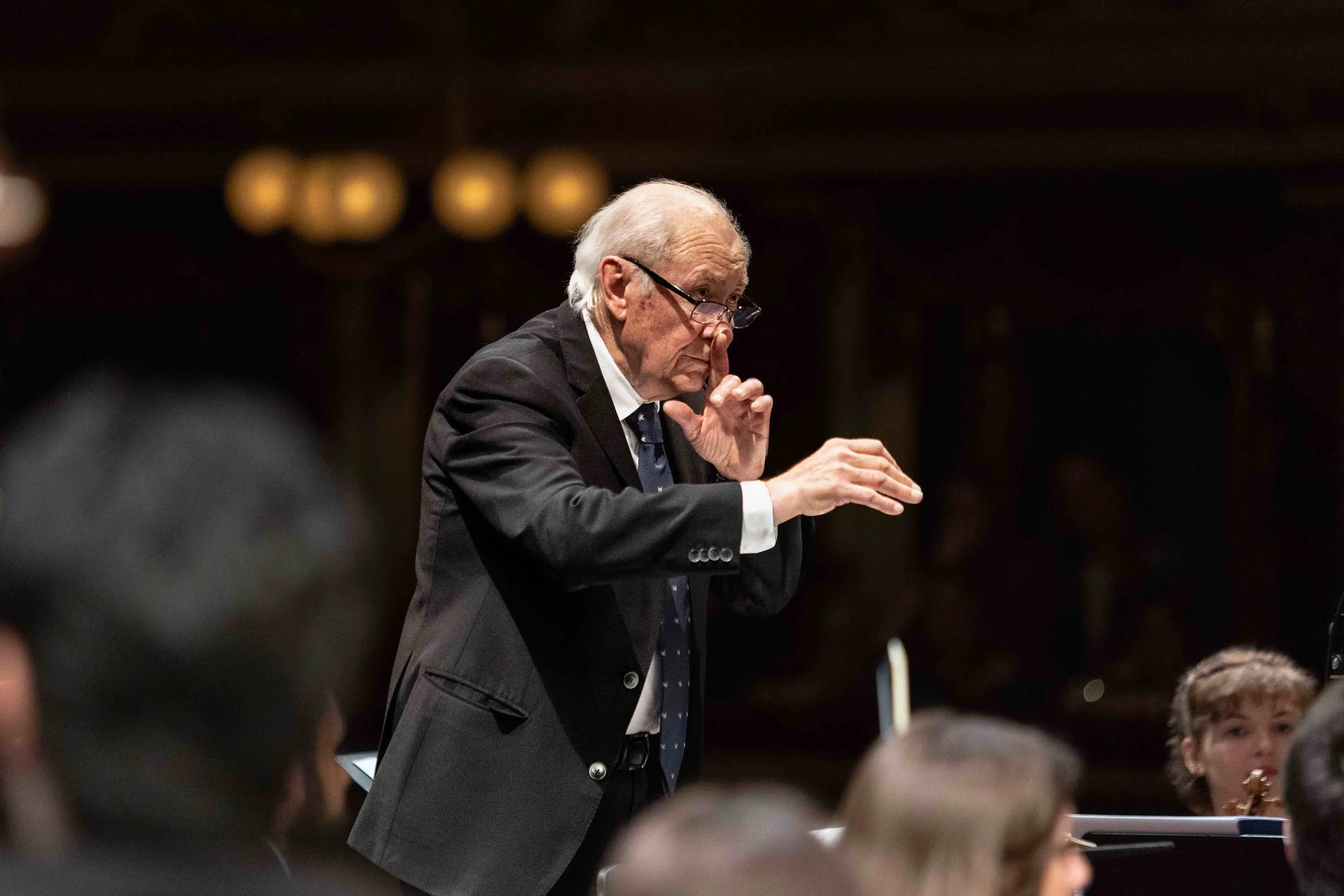 Un anziano direttore d'orchestra dirige con le mani