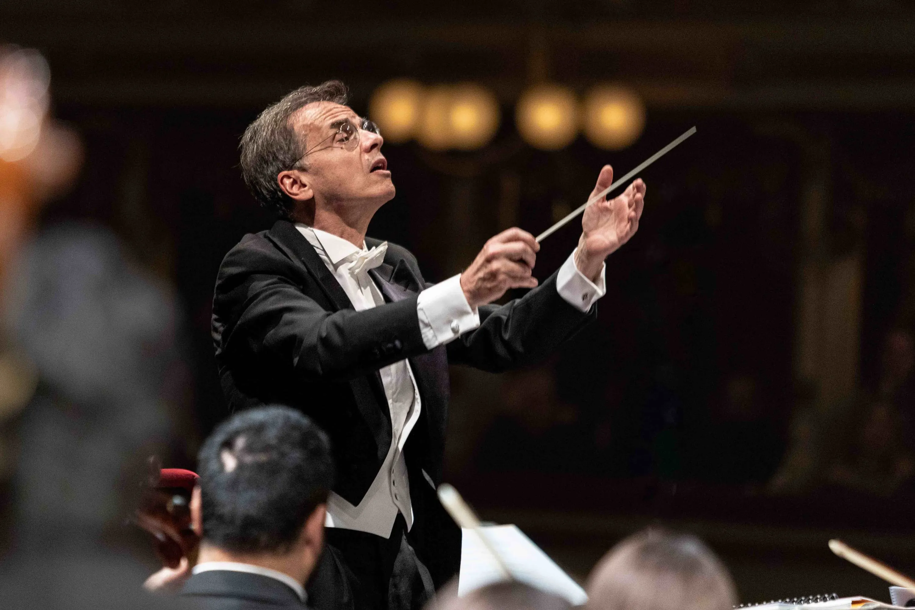 Il direttore d'orchestra in frac dirige con la bacchetta
